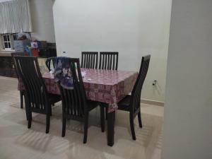 Pasir MasMegat Homestay的餐桌、四把椅子和一张桌布