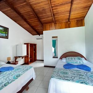 福尔图纳Hotel Villa Fortuna, Volcan Arenal, Costa Rica.的配有木天花板的客房设有两张床。
