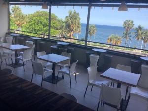 圣多明各Hotel Blue Malecón And Spa的一间带桌椅的海景餐厅