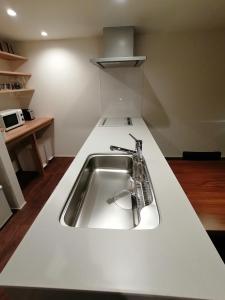 饭山市Aki's Apartments Madarao的厨房配有白色台面上的水槽