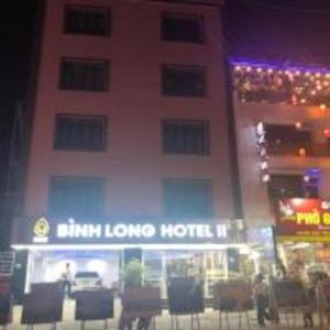 Lai ChâuBình Long II Hotel的夜间在大楼前带椅子的酒店