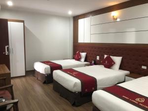 Lai ChâuBình Long II Hotel的酒店客房,配有3张带红色枕头的床