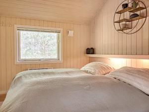 维斯特索马肯Holiday home Nexø X的一间卧室设有一张床和一个窗口