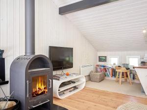 维斯特索马肯Holiday home Nexø X的客厅设有壁炉和电视。