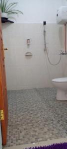 英德FARILA LODGE的一间带卫生间的浴室,铺有瓷砖地板。