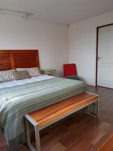 埃尔卡拉法特Casa Glaciar Patagonia的一间卧室配有一张木床和木凳