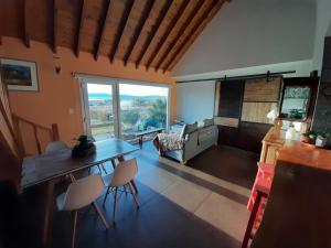 埃尔卡拉法特Casa Glaciar Patagonia的客厅配有桌椅和大窗户