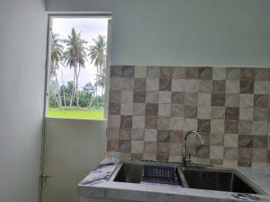 PayakumbuhWafaby Guest House的厨房设有水槽和窗户。
