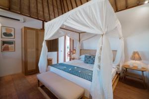 吉利特拉旺安吉利海滩度假酒店的一间卧室配有一张带天蓬的床