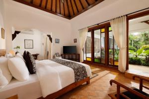 沙努尔Puri Tempo Doeloe Boutique Hotel的卧室配有一张白色大床和电视。