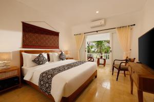 沙努尔Puri Tempo Doeloe Boutique Hotel的一间卧室配有一张大床和电视