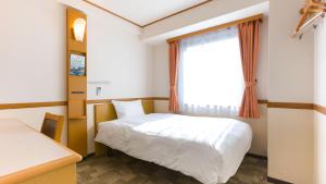 甲府Toyoko Inn Kofu eki Minami guchi No 1的卧室配有白色的床和窗户。