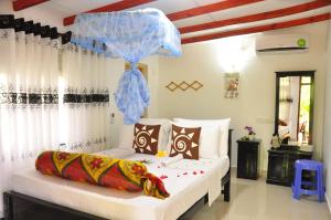 锡吉里亚Another World Hostel Sigiriya的一间卧室配有一张带蓝伞的床