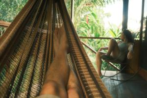 马尔多纳多港Tronco Tambopata Adventure的坐在吊床上坐在椅子上的女人