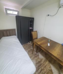 库塔伊西Green Palma的一间卧室配有一张床和一张木桌
