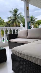 梅尔加Hotel Quinta Ana María的阳台配有2张柳条沙发和棕榈树。