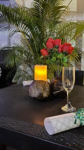 梅尔加Hotel Quinta Ana María的一张桌子,上面放着玻璃、蜡烛和鲜花