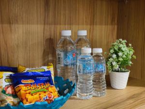 关丹Valley Suites by WyattHomes的桌子上的三瓶水和小吃