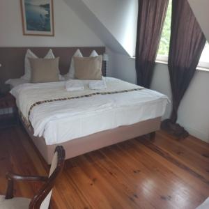 里沃Rewa的一间卧室配有带白色床单和枕头的床。