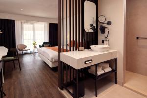 布勒克伦布勒克伦凡德瓦克酒店的一间带水槽的浴室和一张位于客房内的床