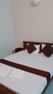 科伦坡MercuryFM 103 Guest House - Colombo 3的客房内的一张带黑色枕头的白色床