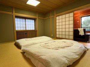 草津FOREST HOUSE的带2扇窗户的客房内的2张床