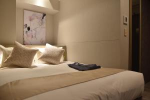 大阪Hotel Cordia Osaka Hommachi的卧室配有一张带白色床单和枕头的大床。