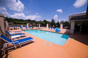 利索尼亚亚特兰大东 - 利松尼亚智选假日酒店及套房的一个带蓝色躺椅的大型游泳池