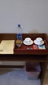 科伦坡MercuryFM 103 Guest House - Colombo 3的一张带盘子的木桌和一瓶水