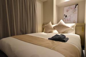 大阪Hotel Cordia Osaka Hommachi的酒店客房,配有一张带浴袍的床
