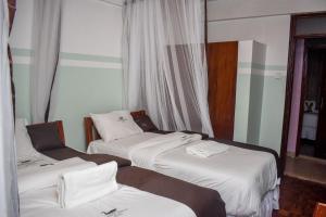 WebuyeGLAMOUR APOLLO HOTEL的酒店客房内的三张床,配有白色床单