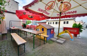 俄斯特拉发伊索拉酒店的一个带长椅和游戏房的游乐场以及一把遮阳伞