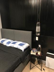 马尼拉Cozy Room, Study Space & Bathtub的一间卧室配有一张床和一张带台灯的桌子