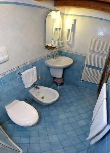 雷妮索雷马尔酒店的蓝色瓷砖浴室设有卫生间和水槽