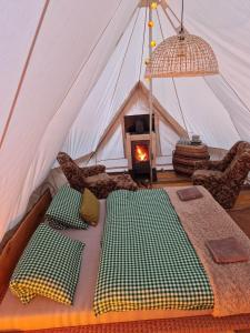 斯托拉Glamping Štôla- Symbioza的帐篷配有一张床和一个壁炉