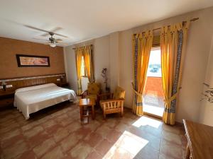 格拉纳达省阿拉马卡诺斯阿尔采瑟餐厅酒店 的一间卧室设有一张床和一个窗口