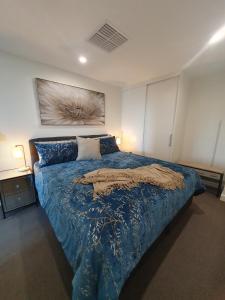 格莱内尔格Colley 11-11 Sub-Penthouse Luxurious Glenelg的一间卧室配有一张带蓝色棉被的床