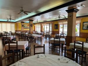 格拉纳达省阿拉马卡诺斯阿尔采瑟餐厅酒店 的一间带桌椅和吊扇的用餐室