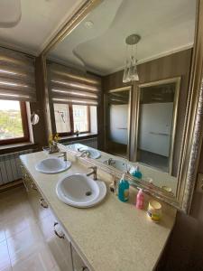 奥什Sultan Sarai Osh的一间带两个盥洗盆和大镜子的浴室