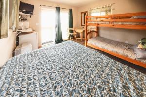 海恩斯Cabin 2 Lynn View Lodge的一间卧室配有一张床和一张双层床。