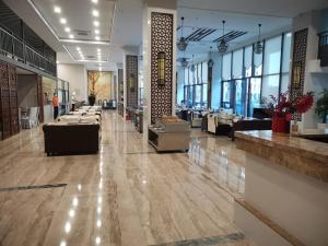 三亚中州国际公寓(三亚湾凤凰机场店)的大厅,在大楼里设有沙发和桌子