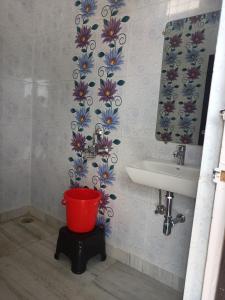 克久拉霍Aarambh Residency的一间带水槽和红色桶的浴室