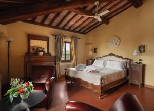 蒙泰斯佩尔托利Villa La Cappella的卧室配有一张床和一张桌子及椅子