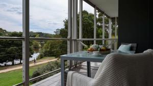 戴尔斯福特Lakeside Suite 3 - Lake View & Spa Bath的设有一个配有桌椅并享有美景的阳台。