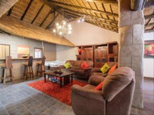 PelindabaMotozi Lodge的客厅配有沙发和桌子。