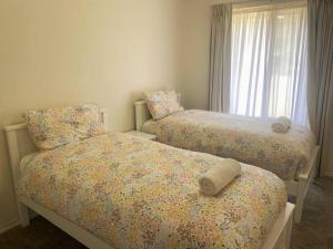 埃斯佩兰斯Thistledome的带窗户的客房内设有两张单人床。