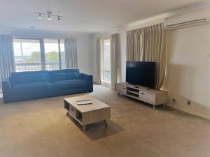 埃斯佩兰斯Thistledome的客厅配有蓝色的沙发和电视