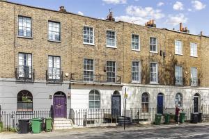 伦敦Camden Town Apartment的街道上一座带紫色门的大型砖砌建筑