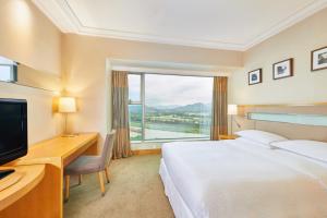 深圳深圳福朋喜来登酒店的配有一张床、一张书桌和一扇窗户的酒店客房