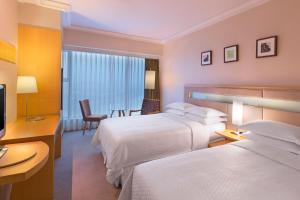 深圳深圳福朋喜来登酒店的酒店客房设有两张床和电视。